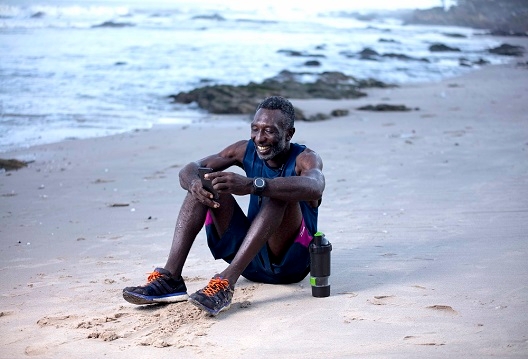 An older man uses his phone to learn about funeral cover benefits online.
