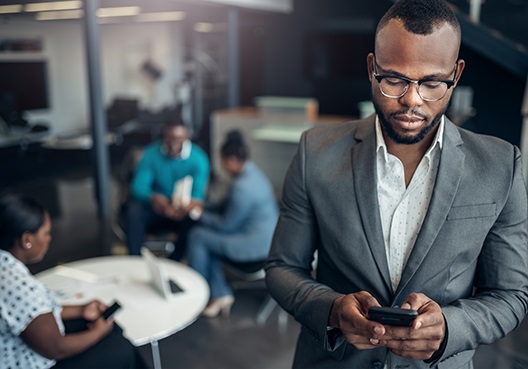 A Ghanaian man looks up information related to credit life assurance policies on his phone