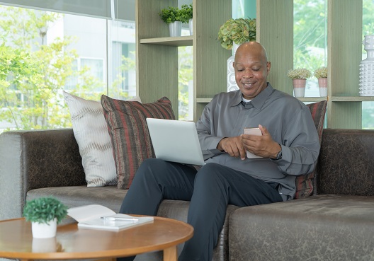 A Ghanaian man goes online on his phone to learn about why he should use a life assurance company.