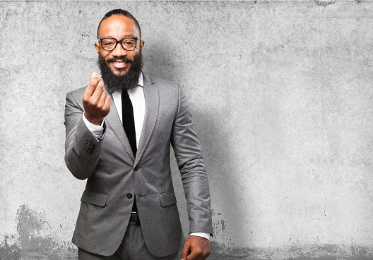 A Ghanaian man dressed in a suit and tie prepares to speak about a pension plan for a company.