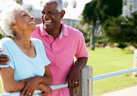 An older couple smile and enjoy spending time outdoors in their retirement.