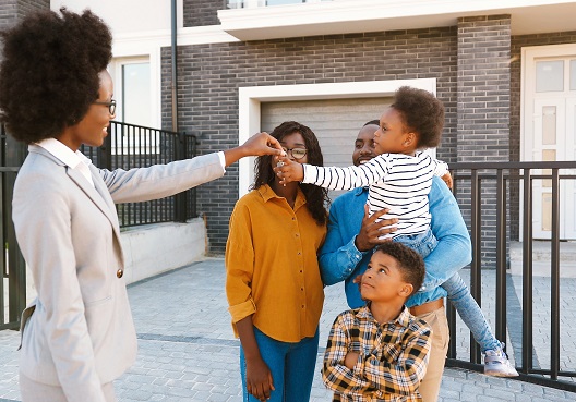 A Ghanaian family with two children accept keys for their new home from their real estate agent.