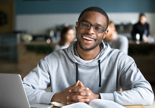 A Ghanaian man smiles in his new office after succeeding in getting a new job with Old Mutual.
